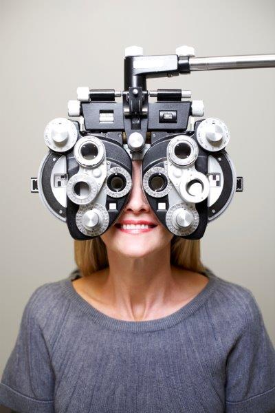 women in optometrist lens switching machine phoropter